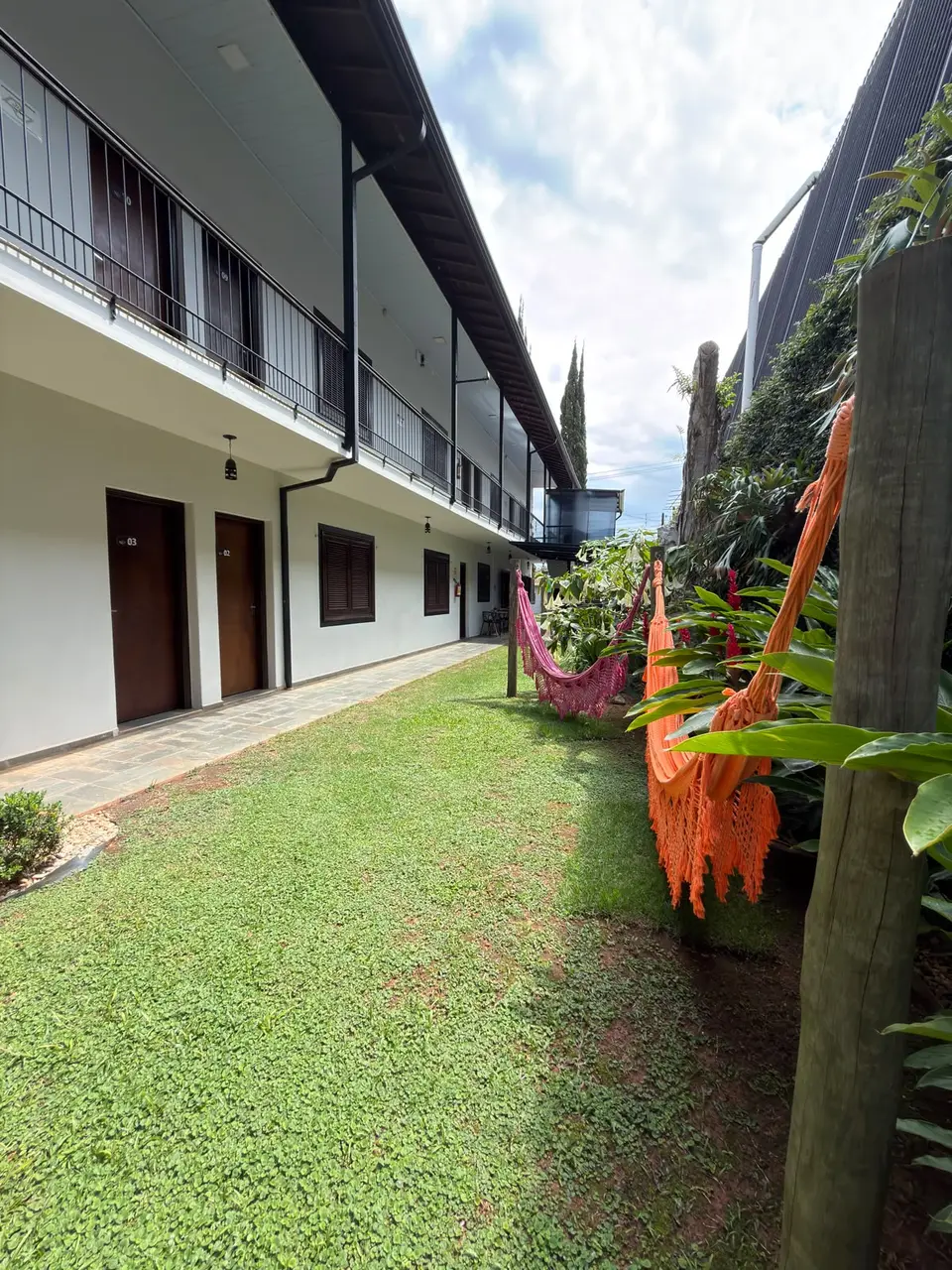Jardim com redes ao lado das suítes